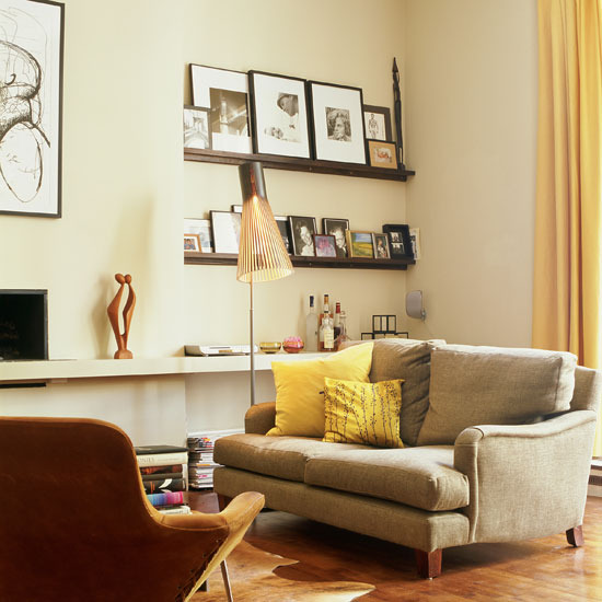 Ghế sofa màu ghi cùng nhiều khung ảnh cũ chính là điểm nhấn tạo nên vẻ hoài cổ cho căn phòng.